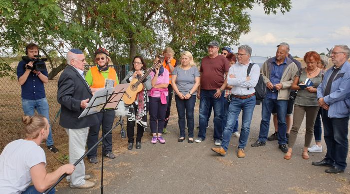 Teilnehmer der Radtour stehen vor dem jüdischen Friedhof.
