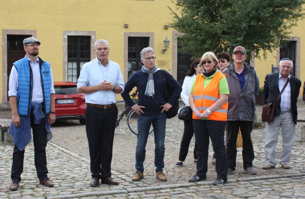 Landrat Stichnoth, Innenminister Stahlknecht, Antisemitismusbeauftragter Dr. Schneiß und Anette Pilz stehen vor dem Bürgerhaus und begrüßen die Teilnehmer.